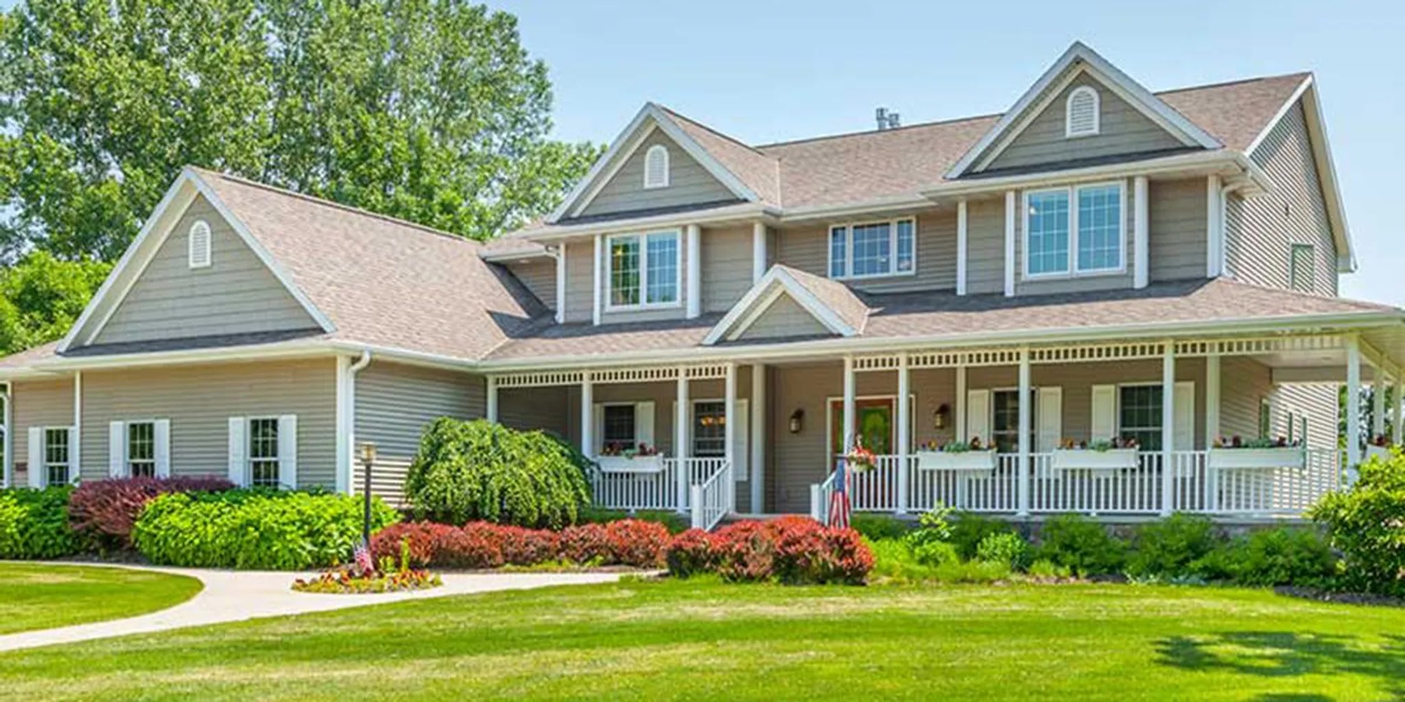 Large home with multiple outdoor AC units as two people review HVAC plans on a screen.